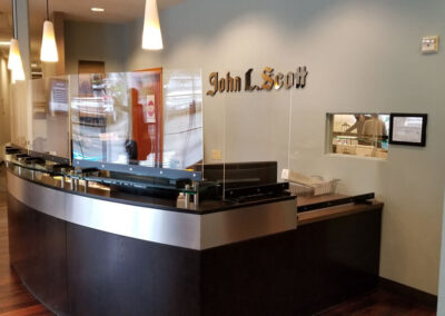 Two custom-made sneeze guards protect the side of the reception desk.